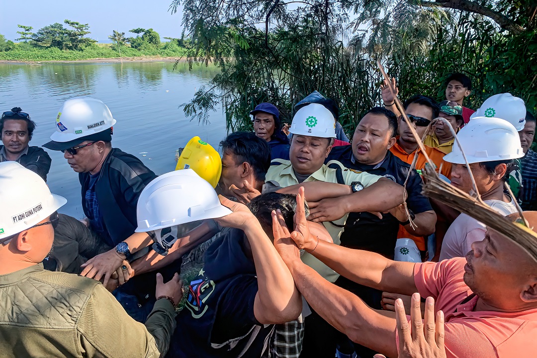 BERAKHIR RICUH: Seorang pekerja yang diduga dari PT CML mengayunkan helm proyeknya untuk menyerang warga yang melakukan aksi demo di belakang PLTU Jeranjang, Lombok Barat, Rabu (24/5).(IVAN/LOMBOK POST)