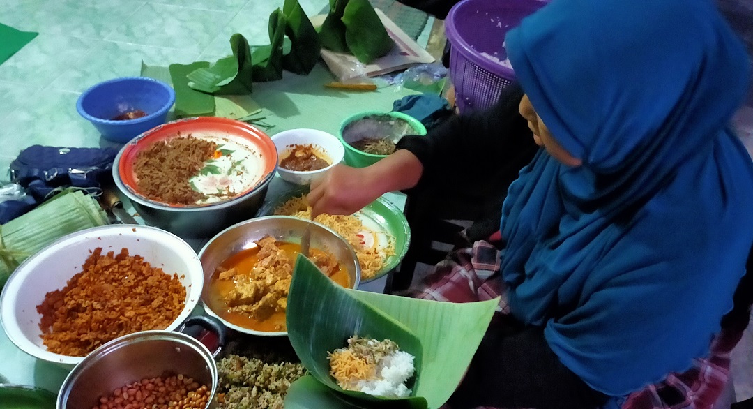 SIAPKAN PESANAN: Pemilik Warung Murni, Murniati sedang menyiapkan pesanan nasi daun reseller di Belencong, Gunungsari, Lombok Barat, beberapa hari lalu.(NURUL/LOMBOK POST)