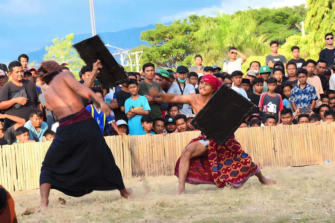 SEMARAK HUT: Dua pepadu tengah bertanding dalam perlombaan peresean di lapangan Tioq Tata Tunaq, Sabtu lalu (22/7). (FERIAL/LOMBOK POST)