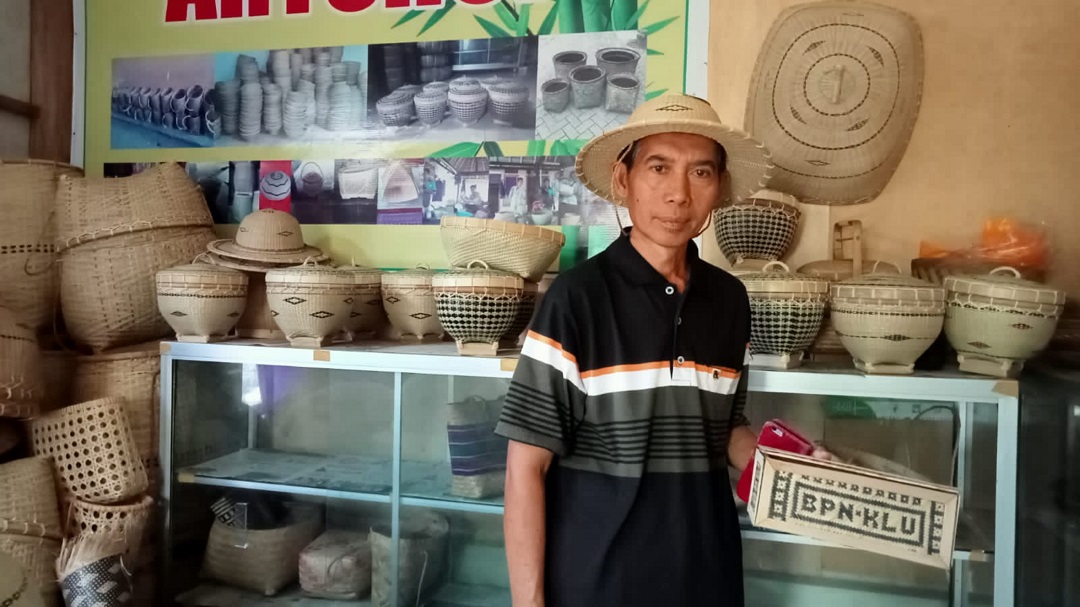 KERAJINAN BAMBU: Wardi menujukkan semua hasil kerajinan bambu yang diproduksi oleh UD Bambu Cerah di Desa Bentek, belum lama ini.(Ferial/Lombok Post)