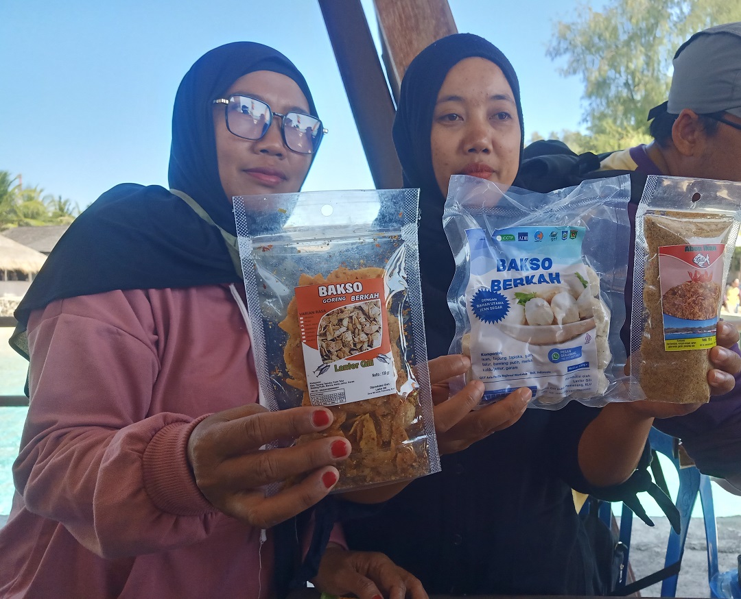 OLAHAN IKAN: Ketua Poklahsar Lanter Gili Sustikayanti (kanan) bersama anggotanya menunjukkan produk hasil olahan ikan kelompoknya di stan Pelabuhan Gili Meno, Jumat (14/7).(FERIAL/LOMBOK POST)