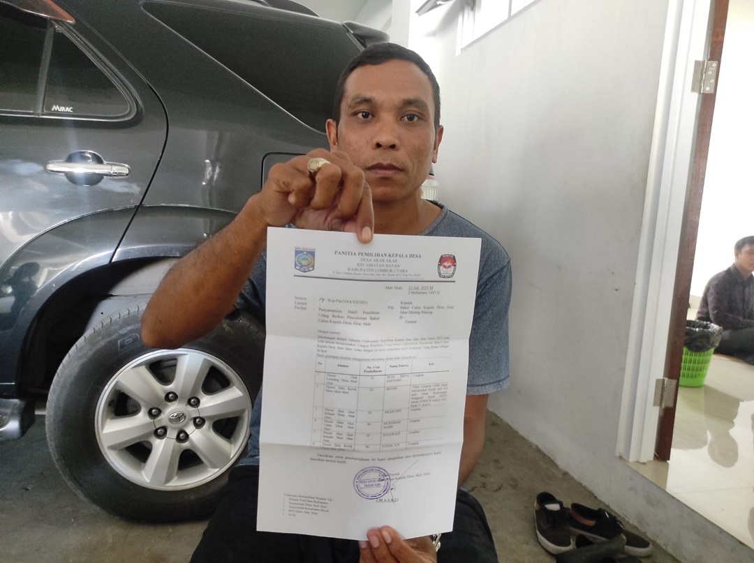 HASIL VERIFIKASI: Cakades Akar-Akar Irham menunjukkan surat pemberitahuan hasil verifikasi administrasi yang diterimanya, kemarin (27/7).(FERIAL/LOMBOK POST)