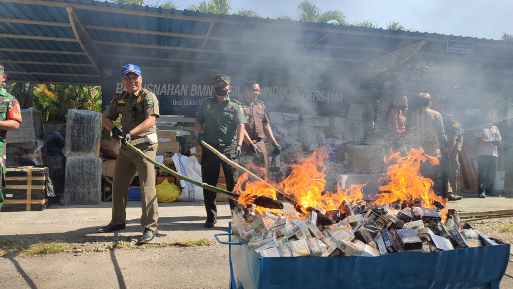 BARANG SITAAN: Petugas memusnahkan rokok ilegal dengan cara dibakar di Kantor Bea Cukai Mataram, Selasa (17/7). (Didit/Lombok Post)