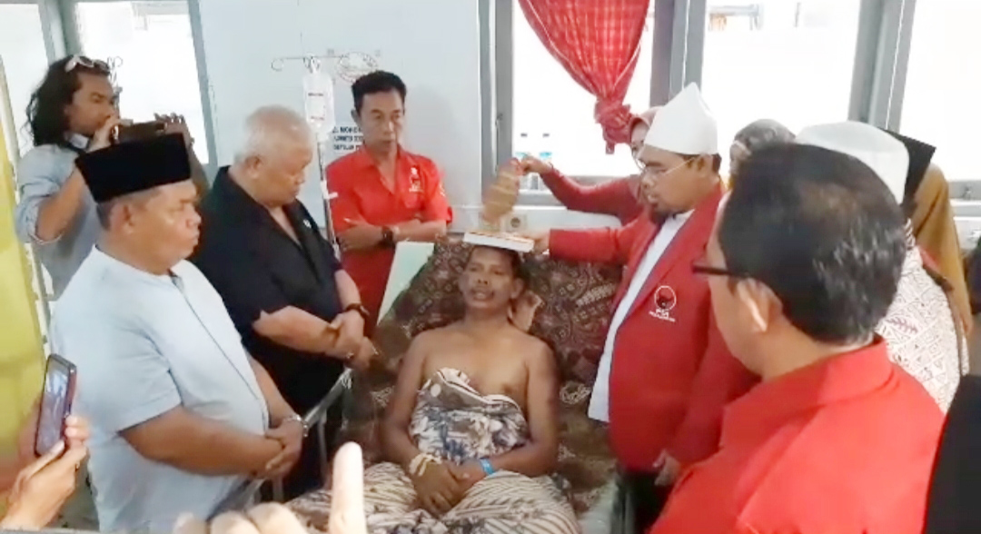 ALQURAN DI ATAS KEPALA: S mengucapkan kata sumpah di RSUD Tripat, Sabtu (22/7). Dalam kata-kata sumpahnya, dia menegaskan tidak pernah melakukan pelecehan kepada anak kandungnya. Foto: Tangkapan layar