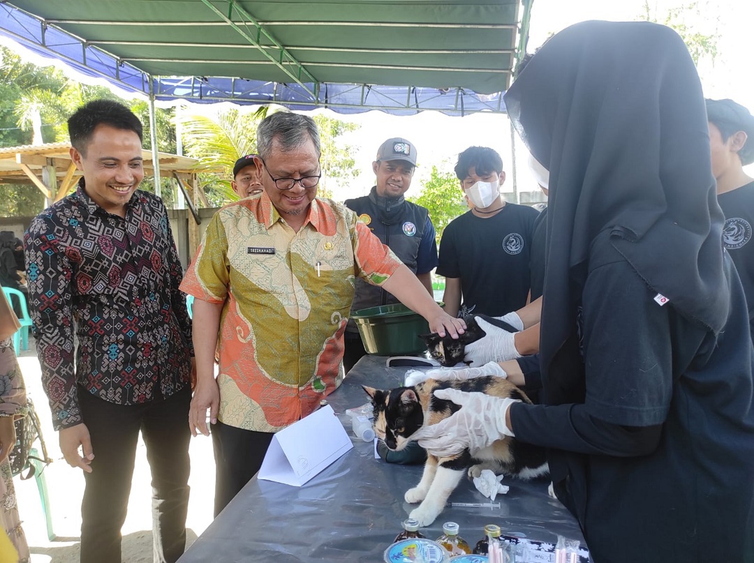 VAKSIN RABIES: Kepala DKP3 KLU Tresnahadi (dua kiri) memantau proses vaksinasi anti rabies pada salah satu kucing peliharaan warga, di UPTD KP3 Tanjung, Kamis (13/7).(FERIAL/LOMBOK POST)