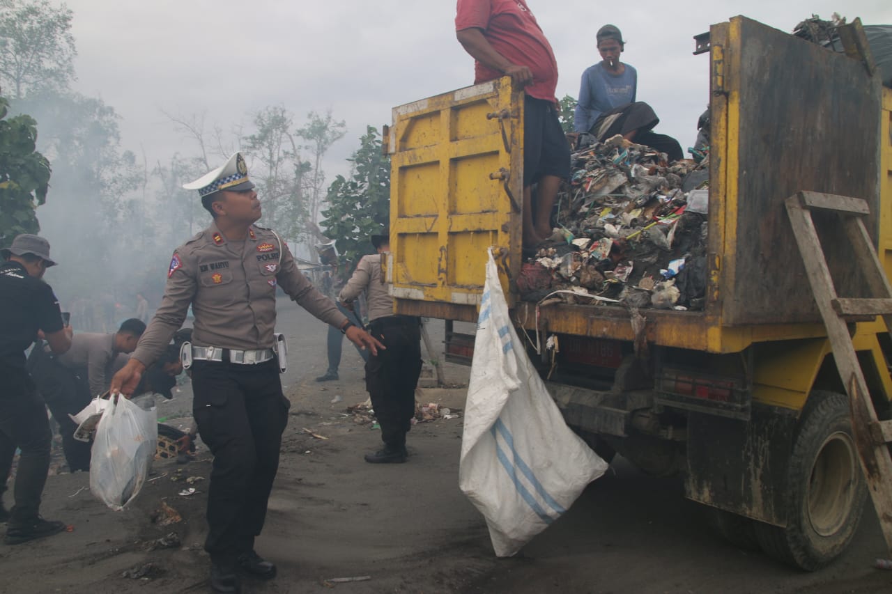 Kanit Regident Satlantas Polresta Mataram Iptu I Komang Wahyu mengangkut sampah ke atas truk Dinas Kebersihan dalam kegiatan bhakti lingkungan yang dilaksanakan Polda NTB bersama Polresta Mataram di Pantai Loang Baloq, Mataram, Kamis (13/7). Foto: Humas P