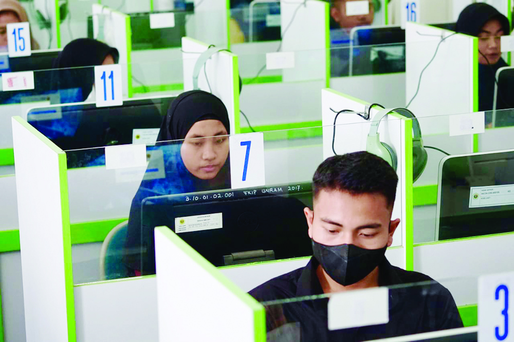 UNTUK MASA DEPAN: Dua peserta menjawab soal, di ujian seleksi jalur mandiri Unram, pekan lalu. (Unram for Lombok Post)