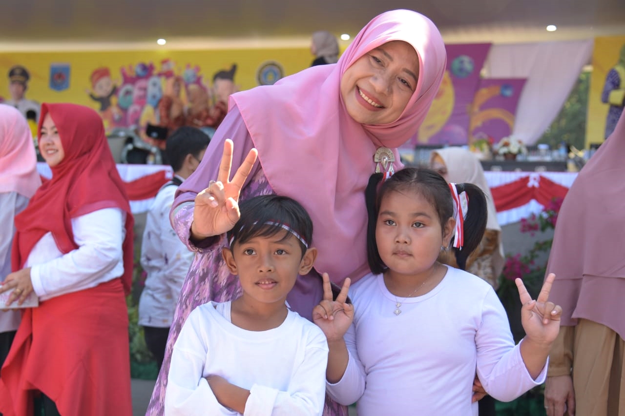 DISKOMINFOTIK NTB FOR LOMBOK POST SENYUM BAHAGIA: Bunda PAUD NTB Hj Niken Saptarini Widyawati Zulkieflimansyah bersama dua peserta didik PAUD, di Gebyar PAUD 2023 Kota Mataram, Senin (7/8). (Diskominfotik for Lombok Post)