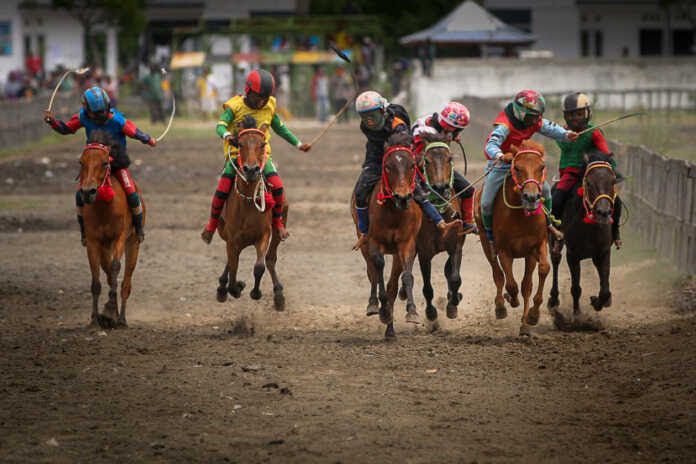 SUDAH MEMBUDAYA: Sejumlah joki cilik tengah memacu kuda balap mereka di arena balap, di Sumbawa, belum lama ini.(Dok/Lombok Post)