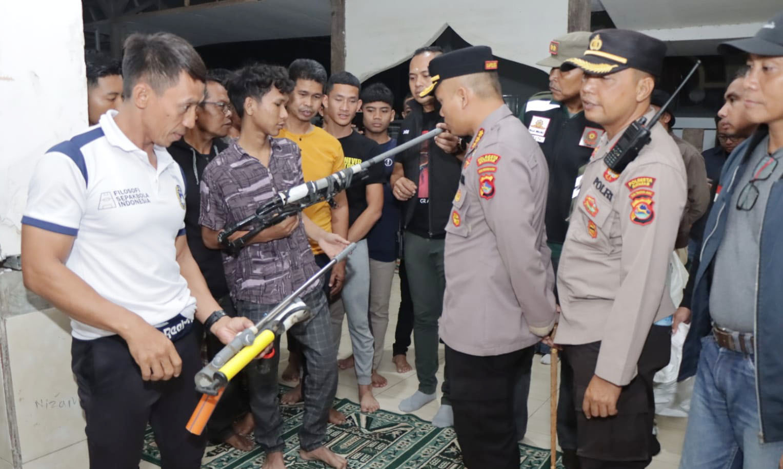 Kapolresta Mataram Kombespol Mustofa (tengah) menerima penyerahan senjata rakitan yang digunakan warga saat konflik antar-lingkungan melalui Kepala Lingkungan Monjok Culik Suhaemi (kiri), Sabtu malam (12/8). Foto: Harli/Lombok Post