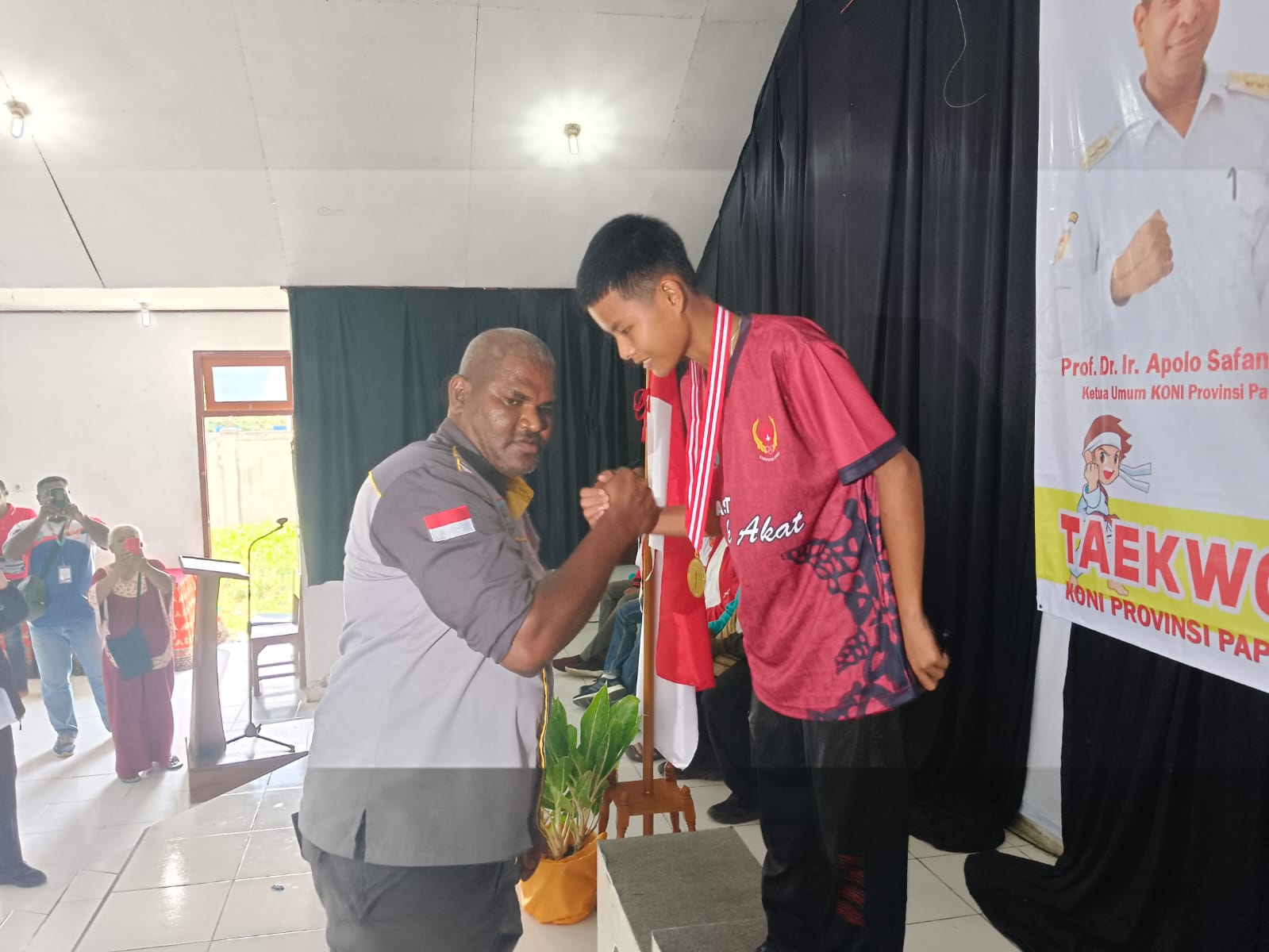Wakil Ketua III KONI Papua Selatan Jeffry Papare saat menyerahkan medali kepada atlet Jerdianto Putra Tandi asal Kabupaten Asmat yang berhasil meraih medali emas pada kategori U45 PA.