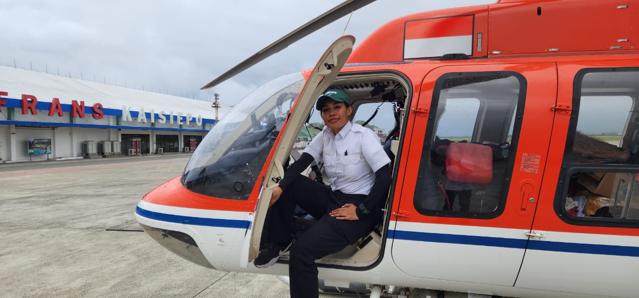 Amigelien Rumbewas Yigibalom Perempuan Papua Pertama Jadi Pilot Helikopter Explore, PT. Sayap Garuda Indah di pintu helikopter.