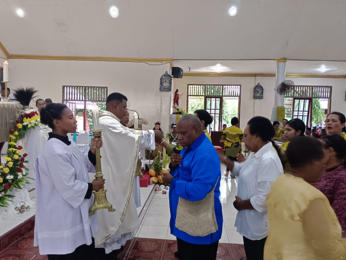 Pastor Stefanus Mahuze, Pr saat membagikan komuni padaa misa perdana yang digelar di Gereja Katolik Paroki Sang Penebus, Kampung Baru Merauke, setelah ditahbiskan jadi imam baru oleh Uskup Petrus Cani