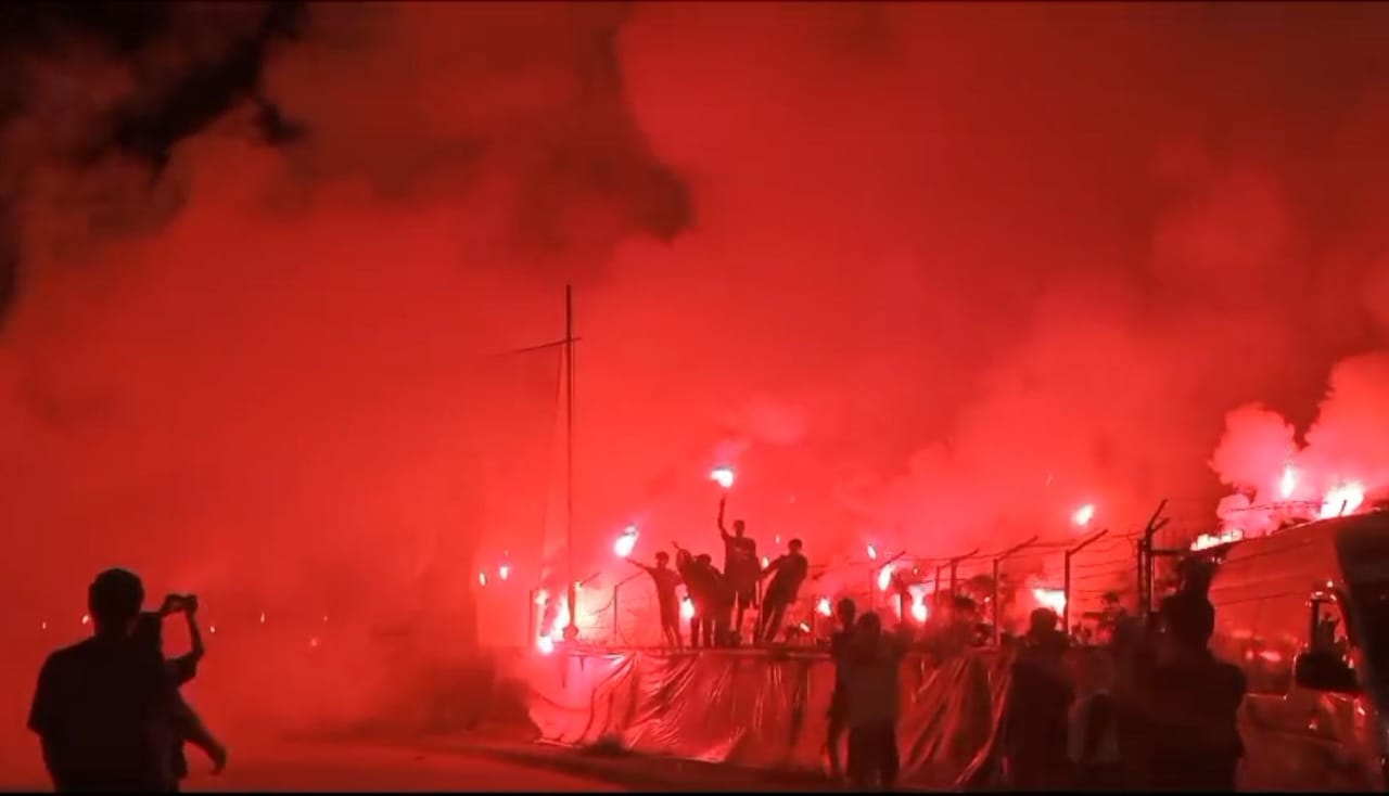 suporter Semen Padang yang menyalakan flare saat laga melawan PSBS Biak di leg kedua Final Liga 2, Sabtu (9/3/2024).