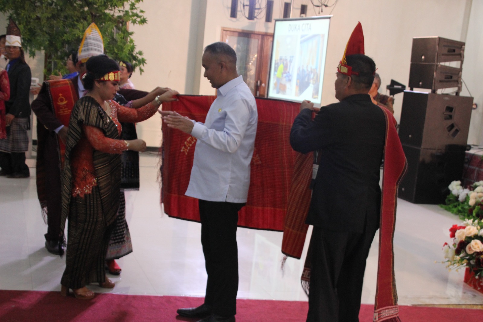 Penjabat Gubernur Papua Pegunungan Dr. Velix Vernando Wanggai, S.IP, MPA saat dipakaikan kain ulos oleh IKB Jayawijaya sebagai salah satu cara penghormatan.