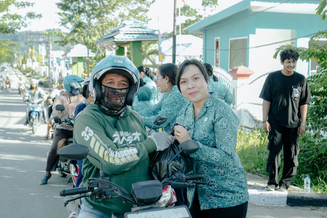 Ketua TP PKK Papua Tengah, Yosina Anwar Damanik saat membagikan paket takjil kepada salah satu pengguna jalan.