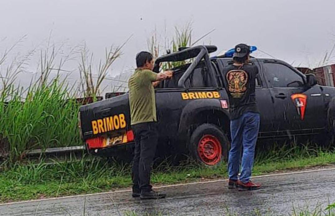 Dua orang anggota Polisi saat hendak mengamankan AM yang membawa kabur mobil Brimob dari parkiran Bandara Sentani, Kabupaten Jayapura, Papua, Jumat (10/05/2024).