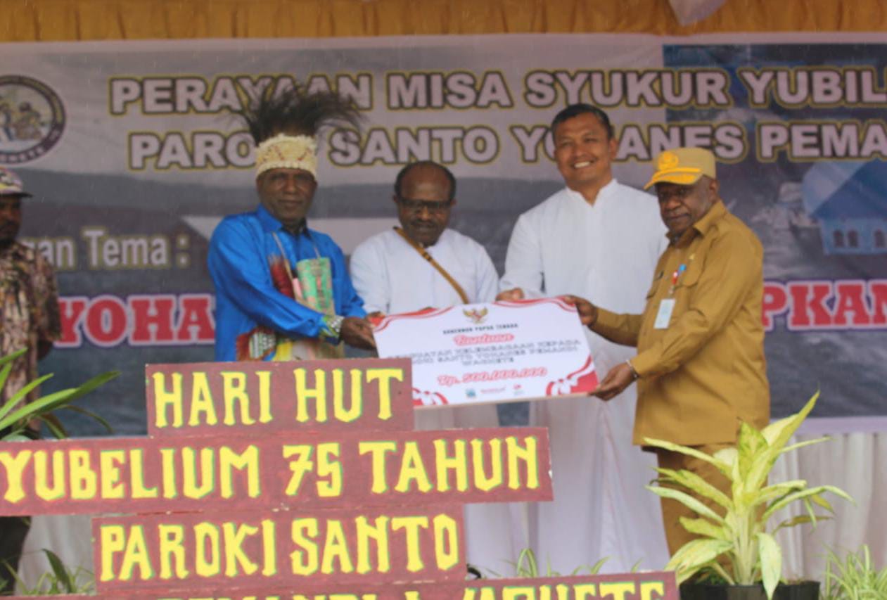 Asisten I Setda Papua Tengah, Ausilius You (Kanan) saat menyerahkan bantuan dari Pemerintah Provinsi Papua Tengah kepada Gereja katolik Paroki Yohanes Pemandi Waghete yang diterima oleh Pastor Dekan