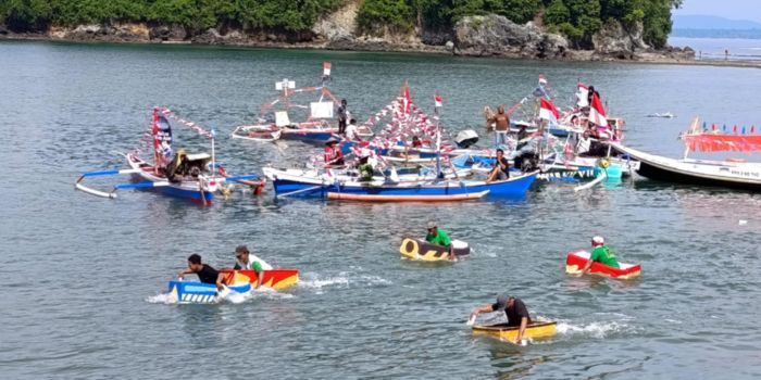 Peserta lomba dayung dari barang bekas yang dimainkan dalam event Festival Kampung Nelayan di Kampung Nelayan, Hamadi, Sabtu (6/7)