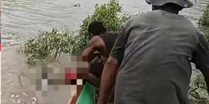 Seorang warga saat menemukan jasad bocah yang tenggelam di Sungai Astj di Asmat Papua Selatan dan hendak mengangkatnya ke dalam perahu untuk dievakuasi.