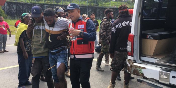 Terlihat seorang warga terluka di bagian paha akibat aksi saling serang di kantor KPU Puncak Jaya.