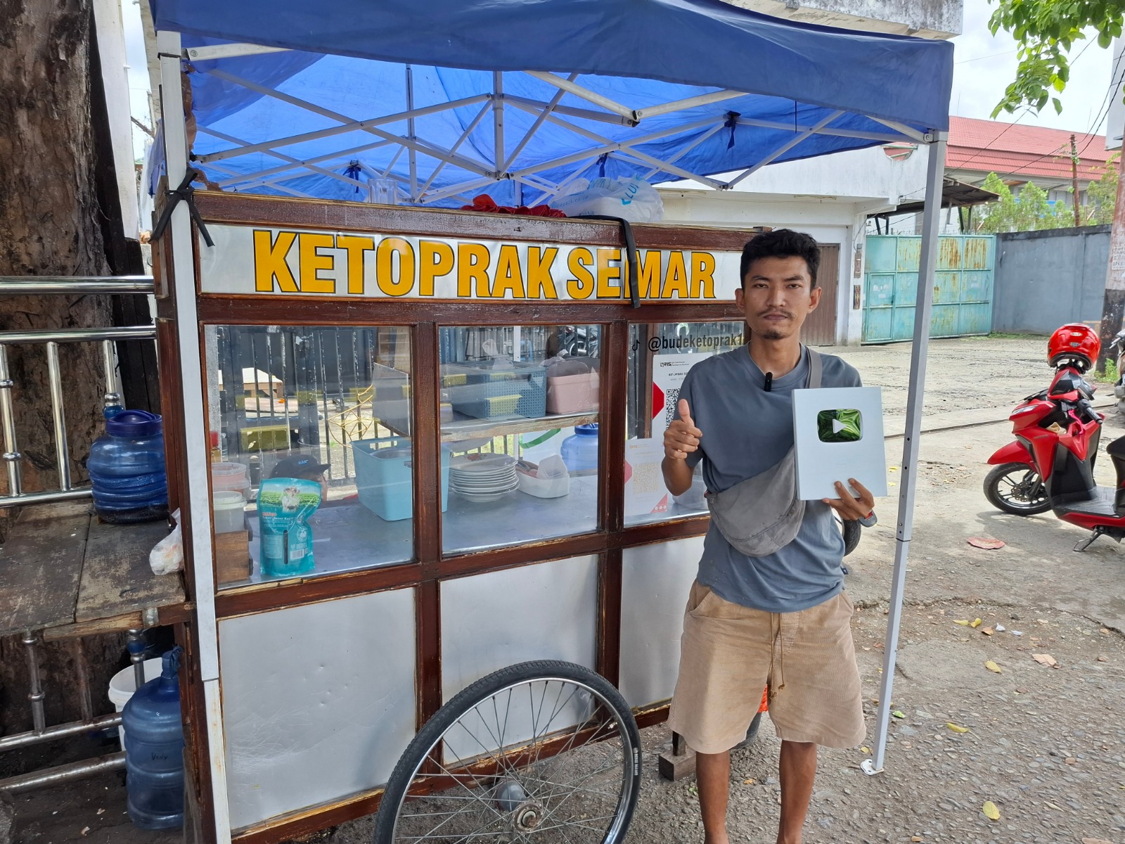 Anang, anak dari penjual ketoprak yang menjadi konten kreator di lapak ibunya saat memperlihatkan plat silver dari Youtube, Senin (3/3). (Mboik Cepos)