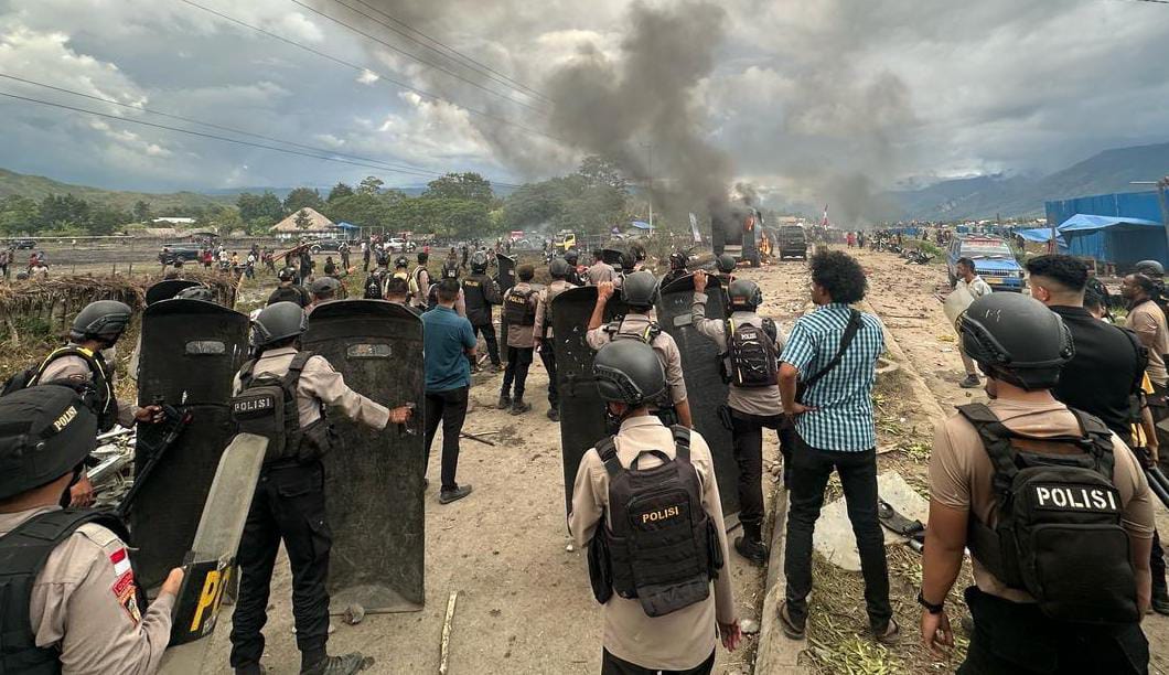 Aparat Kepolisian diserang warga dengan batu saat berupaya melarai dua kelompok masa&nbsp; saling serang ketika syukuran Bupati & Wakil Bupati Jayawijaya dilapangan sinapuk Wamena, Sabtu (15/3/2025).&nbsp;
