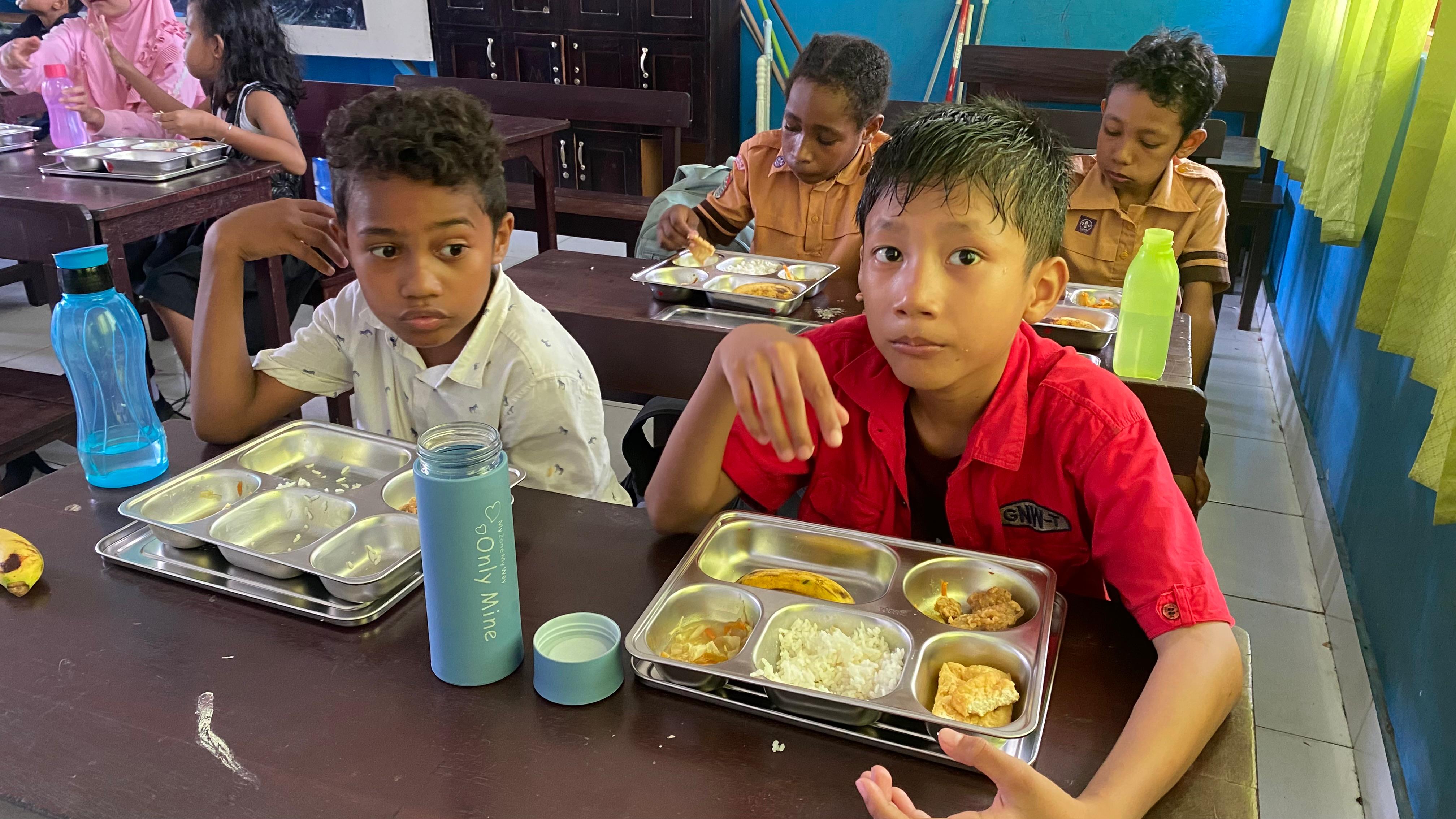 Sejumlah siswa di wilayah distrik Abepura saat menikmati MBG, mengaku senang dan menu makanannya sangat enak, Selasa (15/4/2025)( JIMI/CEPOSONLINE.COM).
