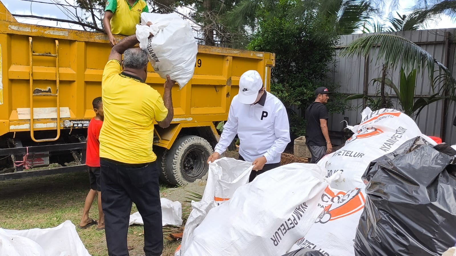 Walikota Jayapura Abisai Rollo dan wakilnya, Rustan Saru saat memikul kantong-kantong sampah kemudian dibuang ke dum truk saat pencanangan kebersihan di Pantai Holtekamp, Sabtu (3/5/2025.