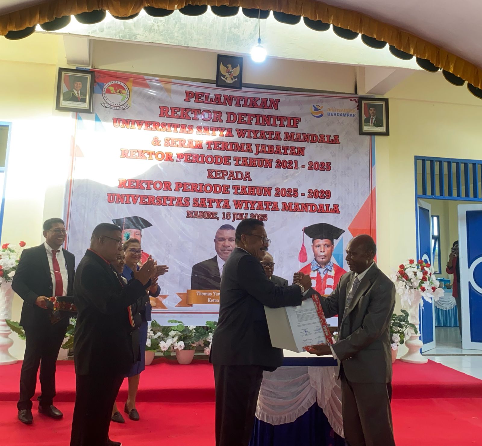 Mantan Wakil Rektor USWIM Nabire, Dr. Drs. Petrus Izaak Suripatty, M.Si, (Kiri) saat menyerahkan SK Serah terima Jabatan kepada Rektor USWIM Nabire yang baru Dr. Petrus Tekege, SH., MH (Kanan).