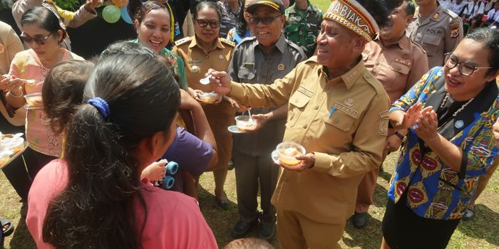 Bupati Biak Numfor saat menyuapi anak-anak yang diberikan makanan tambahan bergizi, menyambut Hari Anak Nasional, Selasa (22/7).