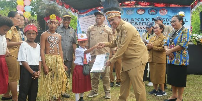 Bupati Markus Mansnembra saat menyerahkan dokumen akta kelahiran pada salah satu anak yang belum memiliki dokumen tersebut, di Kampung Kanaan, Wardo Distrik Biak Barat, Selasa (22/7).