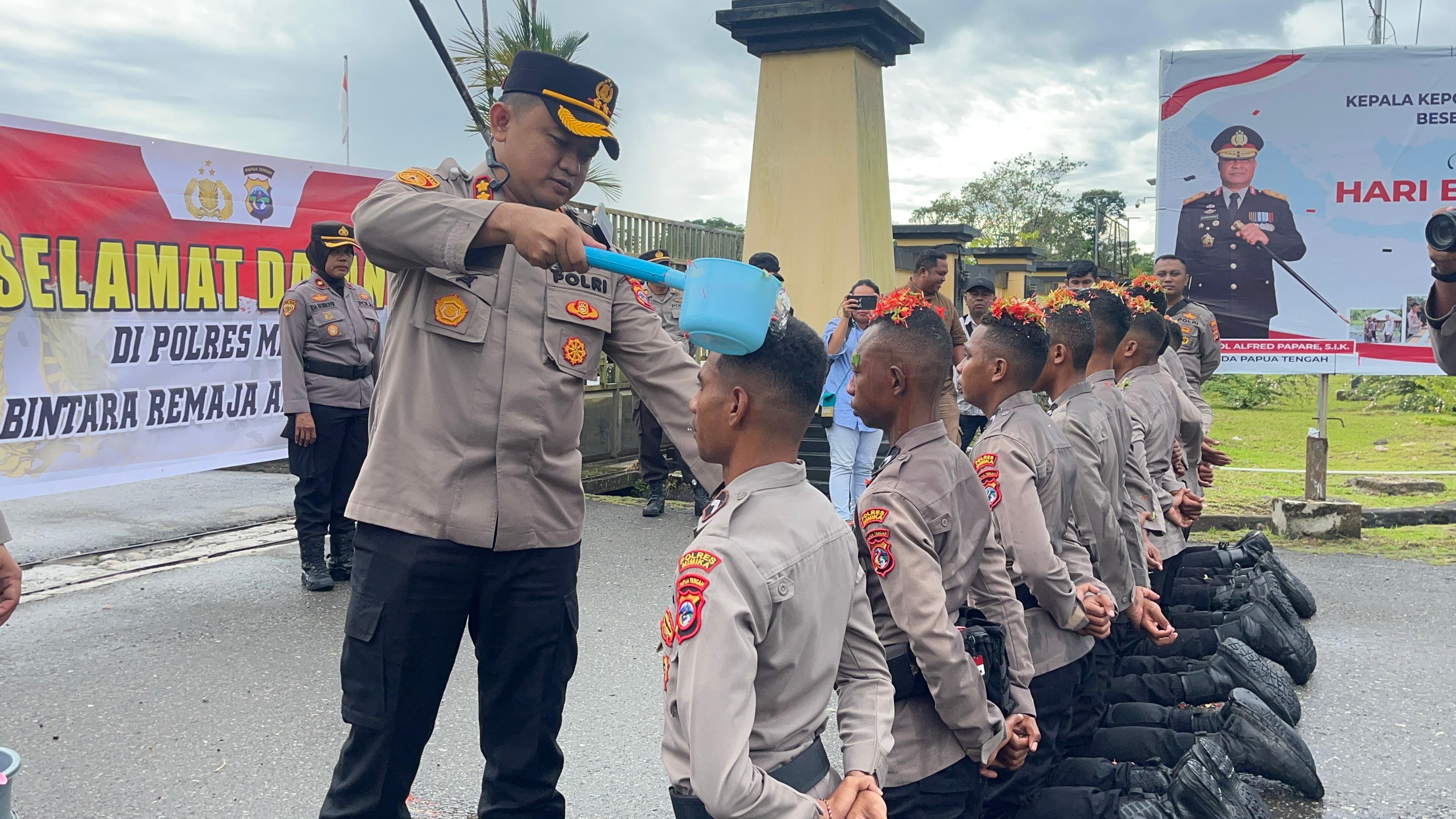 Momen Kapolres Mimika menyiram air bunga sebagai tanda penerimaan para Bintara Remaja angkatan 52 di Mapolres Mimika, di Jalan Agimuga, Mile 32, Mimika, Papua Tengah.
