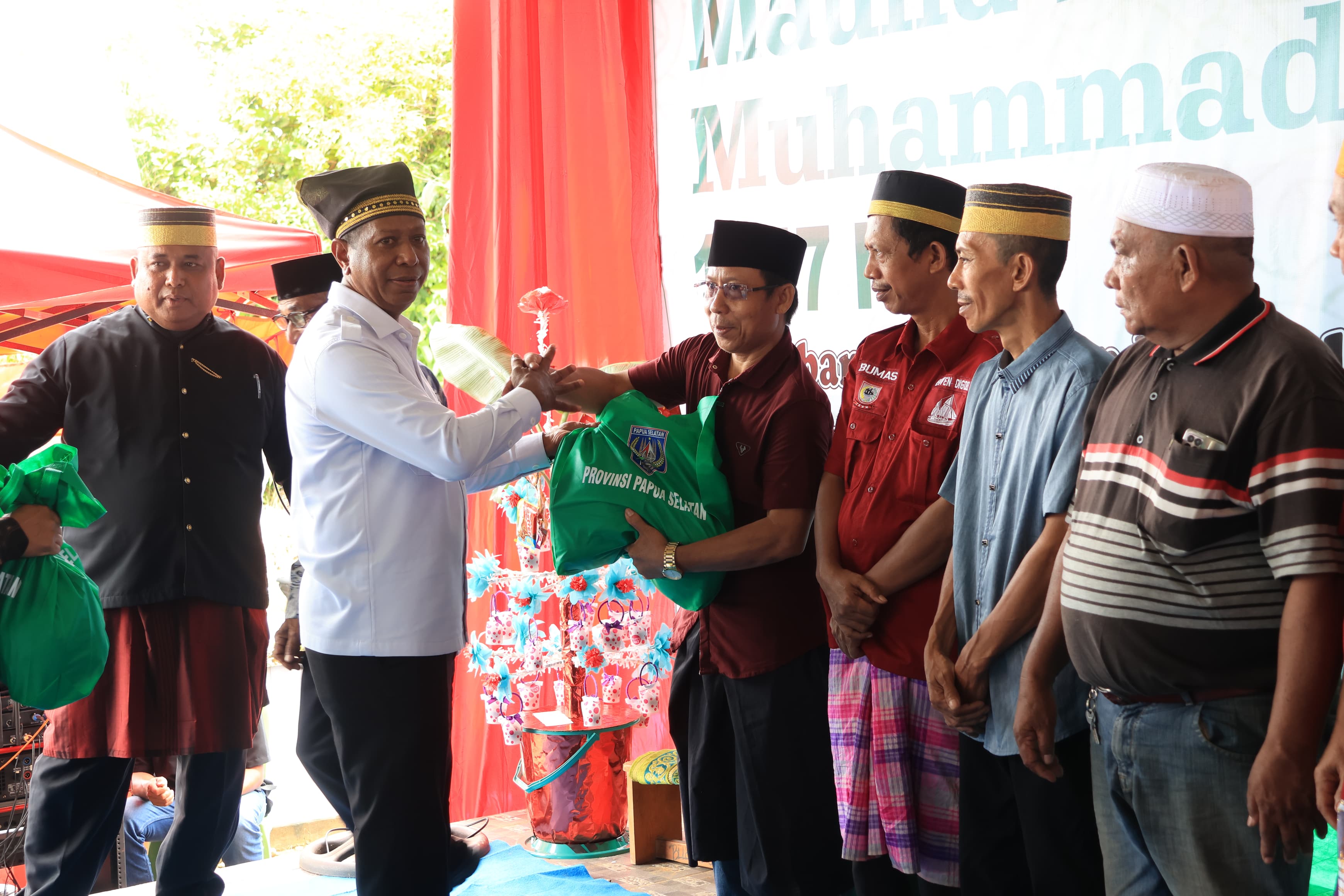 Gubernur Papua Selatan,Apolo Safanpo saat menyerahkan bingkisan pada peringatan Maulid Nabi Besar Muhammad oleh Bugis Makassar di Bala Lompoa, Tanah Merah, Sabtu (6/9/2025).