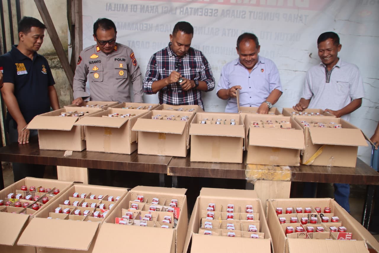 Kasat Narkoba Ipda Daniel Rumpaidus dan Kapolsek Merauke Kota AKP Susanto Bakri dan Kanit Reskrim Polsek Merauke kota Iptu Y. Sitanggang saat menunjukkan minuman keras yang berhasil disita.