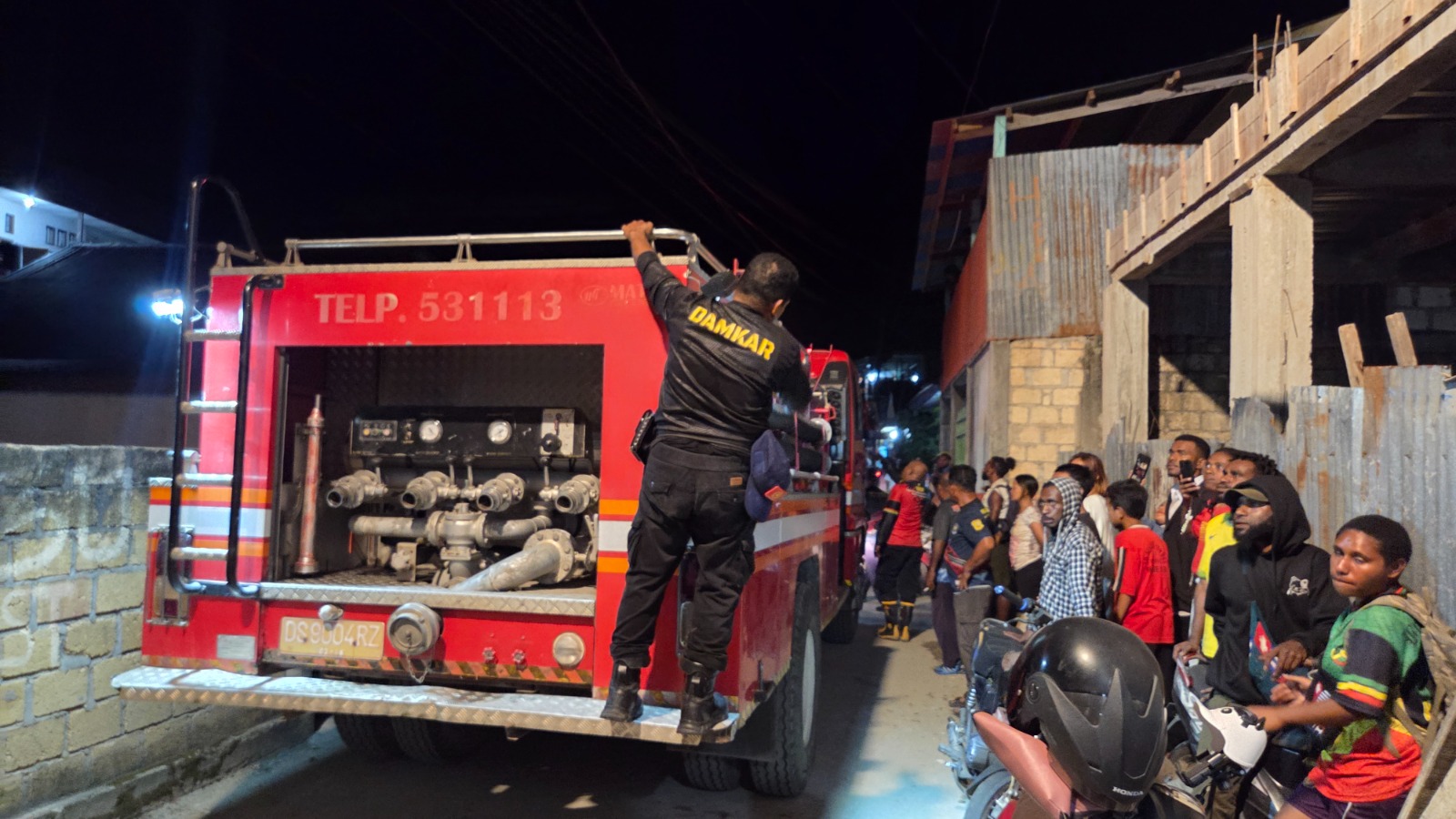 Mobil kebakaran yang kesulitan keluar gang usai memadamkan api di lokasi kebakaran di Jalan Kampung Buton, Perumnas II, Kelurahan Yabansai, Distrik Heram, Kota Jayapura, Jumat (26/9) malam.
