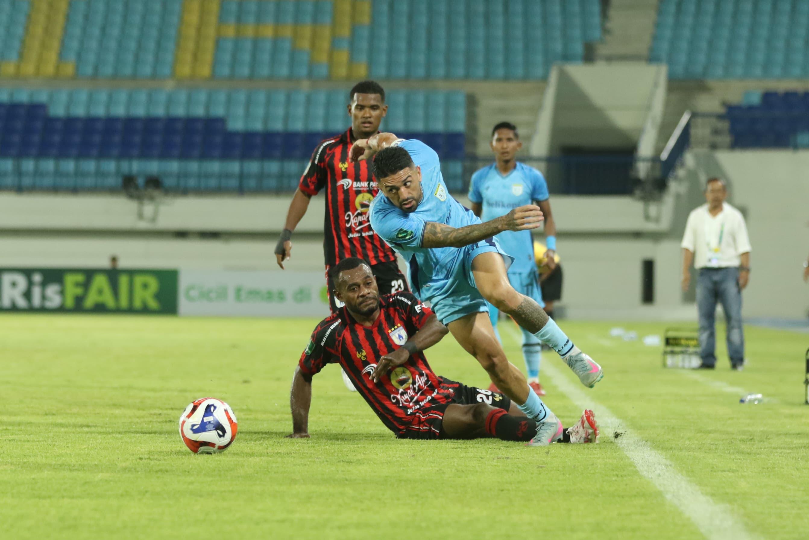 Pemain Persipura Jayapura saat dikawal ketat pemain tuan rumah Persela Lamongan di Stadion Surajaya Lamongan, Senin (6/10/2025) malam. (RADAR LAMONGAN/ANJAR PRADIPTA)