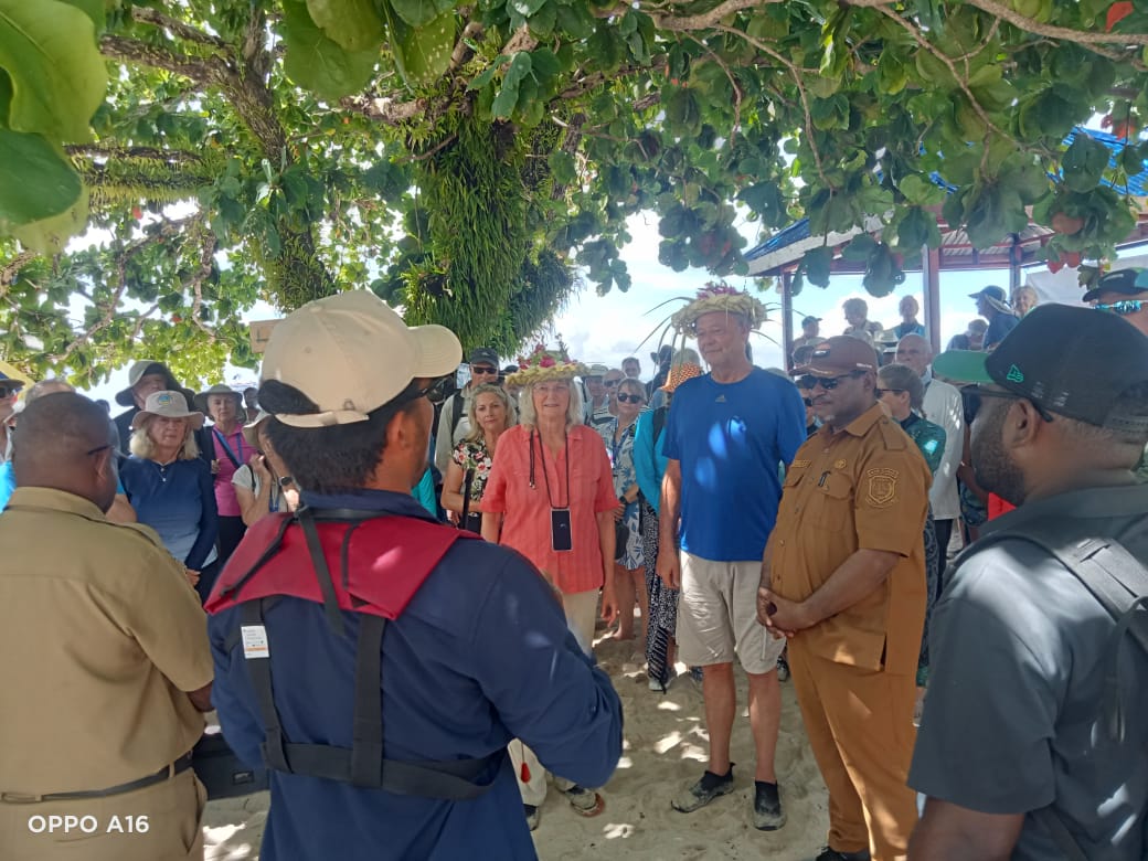 Sekda Kabupaten Sarmi, Eduard Simomonmau bersama tamu wisatawan dan masyarakat Pulau Liki usai prosesi penyambutan di pantai Pulau Liki, Senin (13/10/2025). (CEPOSONLINE.COM/Vicky Ambani)