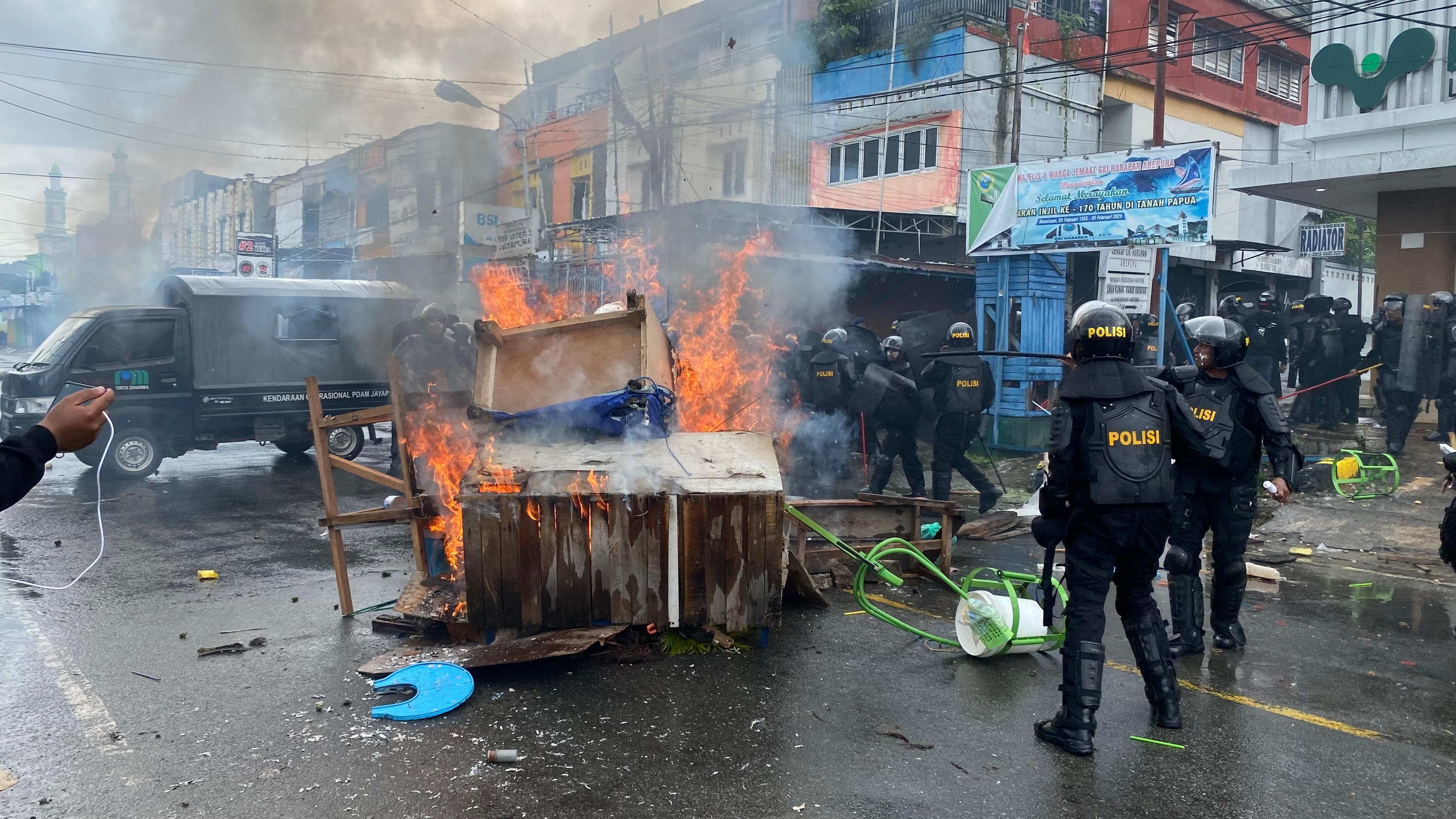 Tampak Kaca depan kendaraan milik polisi dan grobak milik warga menjadi sasaran amukan massa di Abepura, Rabu (15/10/2025).