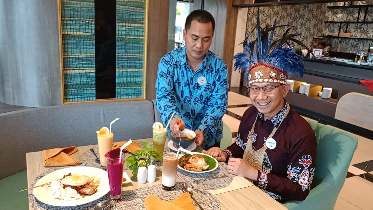 General Manager Hotel Mercure Jayapura, Andreas Riyadi, saat menikmati Nasi Gandul yang kuahnya langsung disiramkan oleh pelayan restoran, Jumat (7/11/2025) (CEPOSONLINE.COM/PRIYADI)