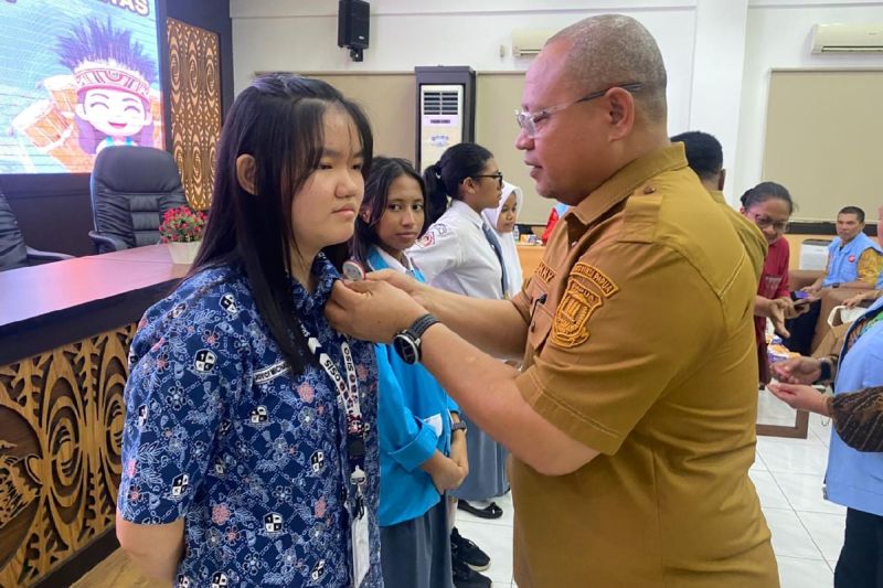 Kepala Inspektur Daerah Papua, Danny Korwa saat menyematkan pin duta intergritas pada salah satu peserta kegiatan pengembangan kapasitas duta integritas bagi pelajar SMA dan SMK di aula Kominfo.