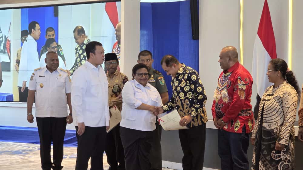 Wamendagri Ribka Haluk saat menyerahkan sertipikat kepada Wawali Kota Jayapura, Rustan Saru, usai Sosialisasi Pengadministrasian dan Pendaftaran Tanah Ulayat Provinsi Papua Tahun 2025.