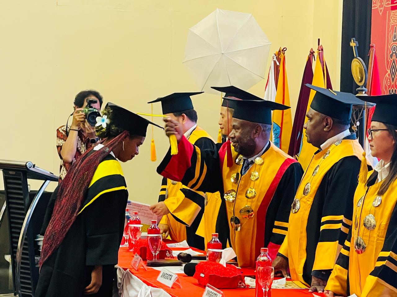 Rektor UNIBA Papua Marthen Medlama saat memindahkan kucir salah satu wisudawati di Hotel Baliem Pilamo Wamena, Jumat (21/11/2025).(Ceposonline.com/Deni Tonjau)