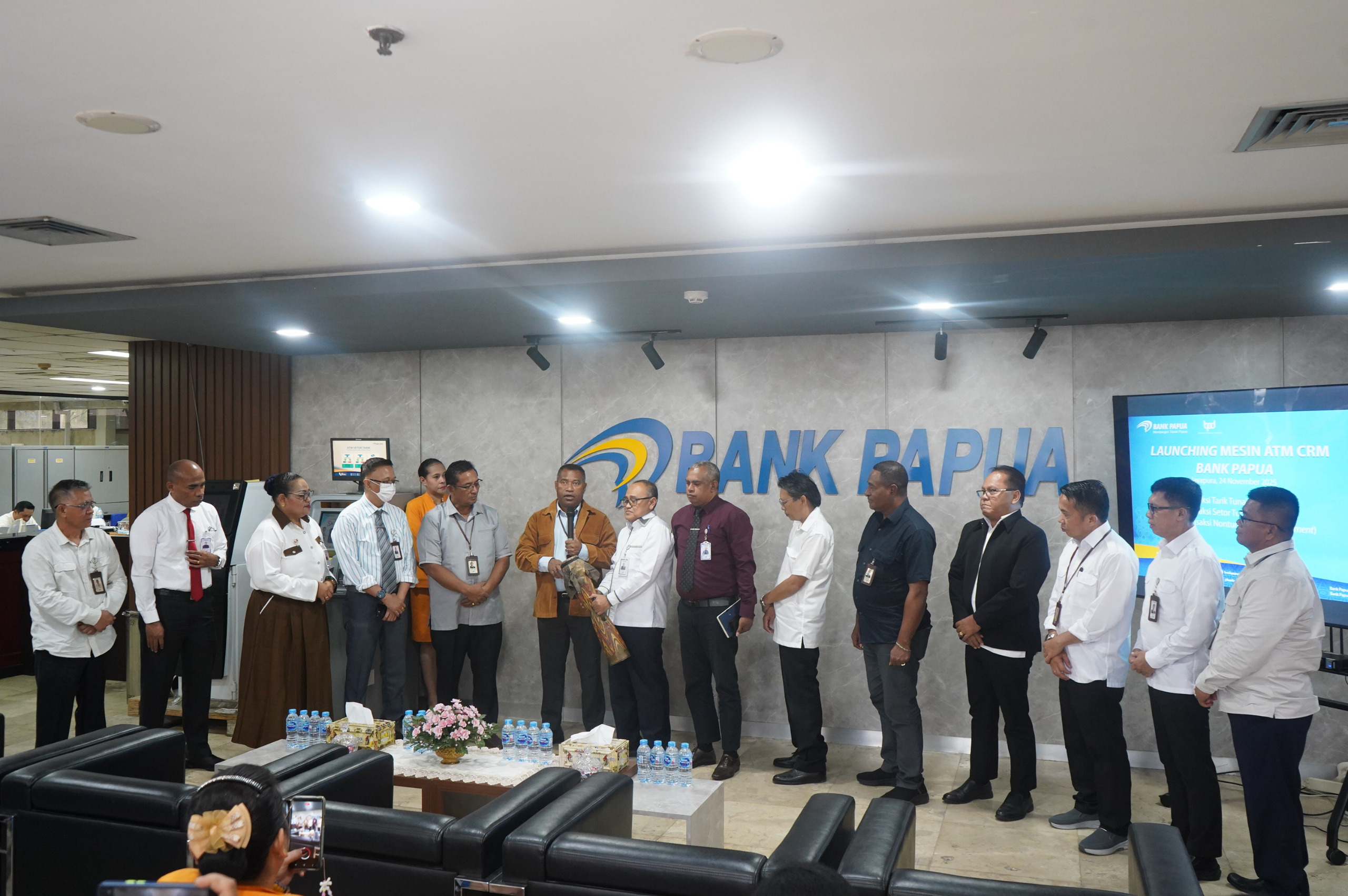 Pemukulan tifa oleh Direktur Operasional Bank Papua Isak S.Wopari, Direktur Keuangan Pujianto, disaksikan Pemimpin Divisi dan Pemimpin Cabang KCU Jayapura dalam launching Mesin ATM CRM Bank Papua.