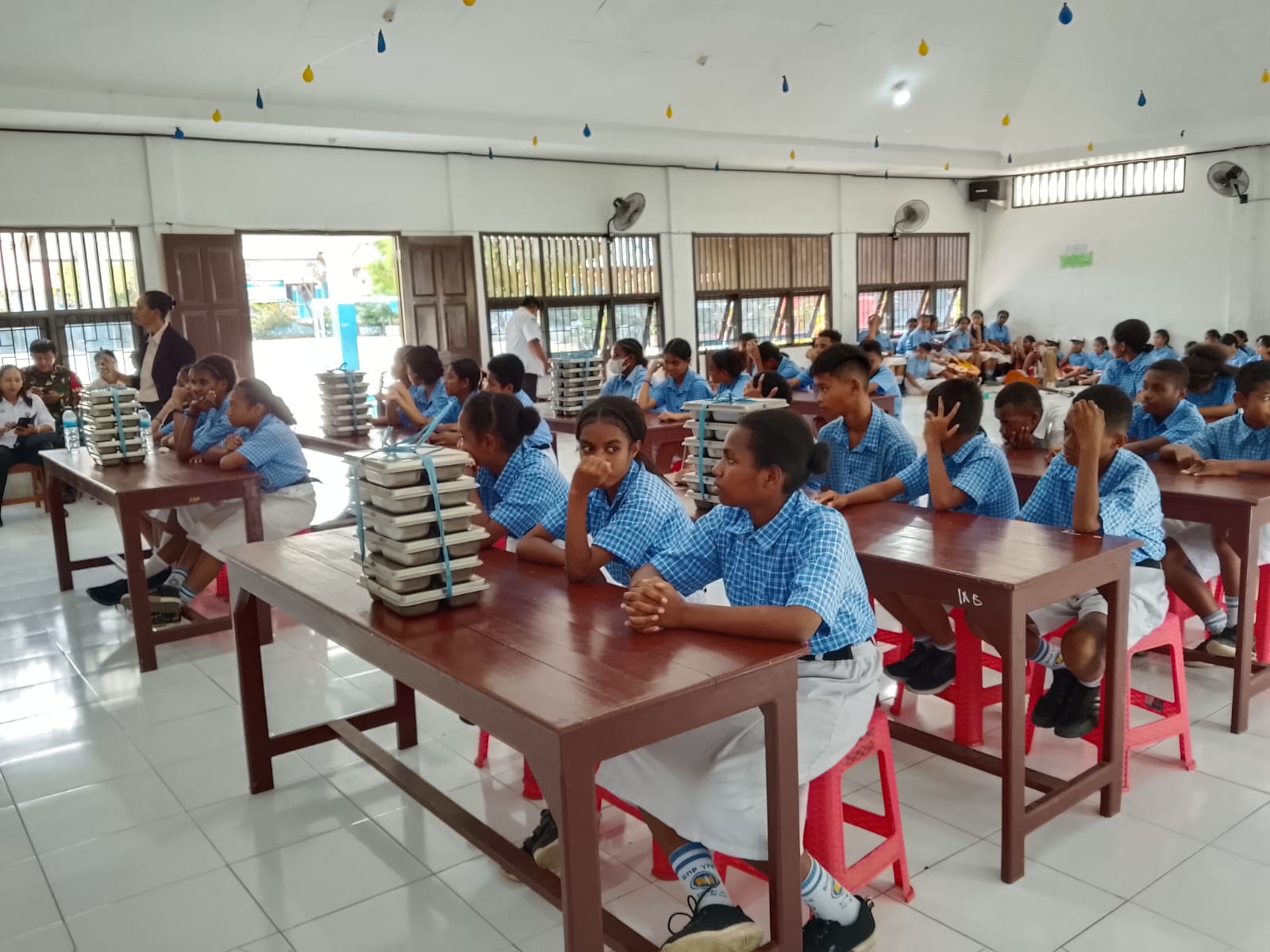 Tampak Siswa-siswi sekolah sedang mendengar Arahan Badan Gizi Nasional sebelum menikmati program Makan Bergizi Gratis.