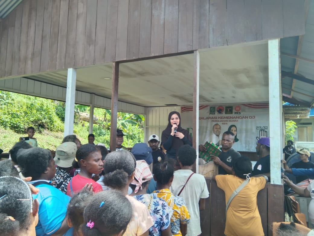 Wakil Bupati Sarmi Jumriati menyerahkan bingkisan Natal kepada warga di Posko Tim Pemenang DJ, Kampung Lembah Neidam, Distrik Sarmi, Jumat (19/12/2025). (Ceposonline.com/Vicky Ambani)