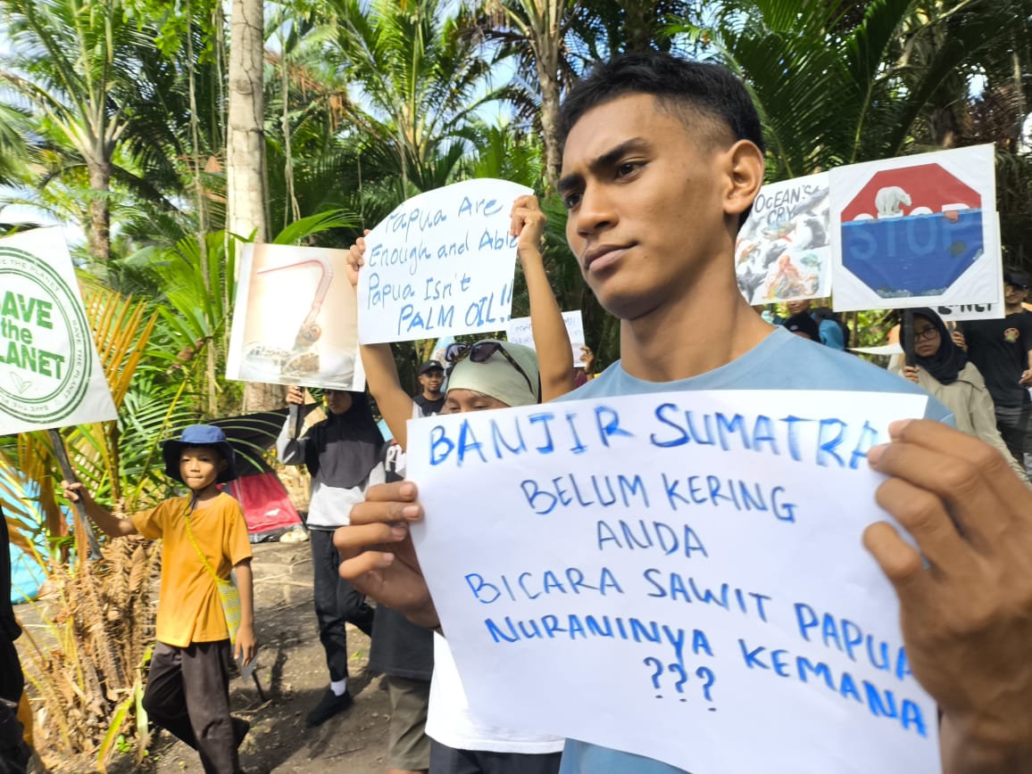 Puluhan anak muda peduli lingkungan menunjukkan berbagai tulisan yang mengkritisi kebijakan Presiden Prabowo terkait perkebunan sawit di Papua, Minggu (21/12/2025). (CEPOSONLINE/GAMEL)