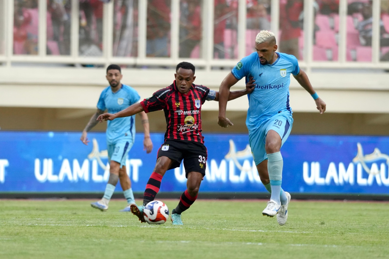 Pemain Persela Lamongan saat berebut bola dengan pemain Persipura, Gunansar Mandowen. (CEPOSONLINE.COM/ISTIMEWA PERSIPURA).