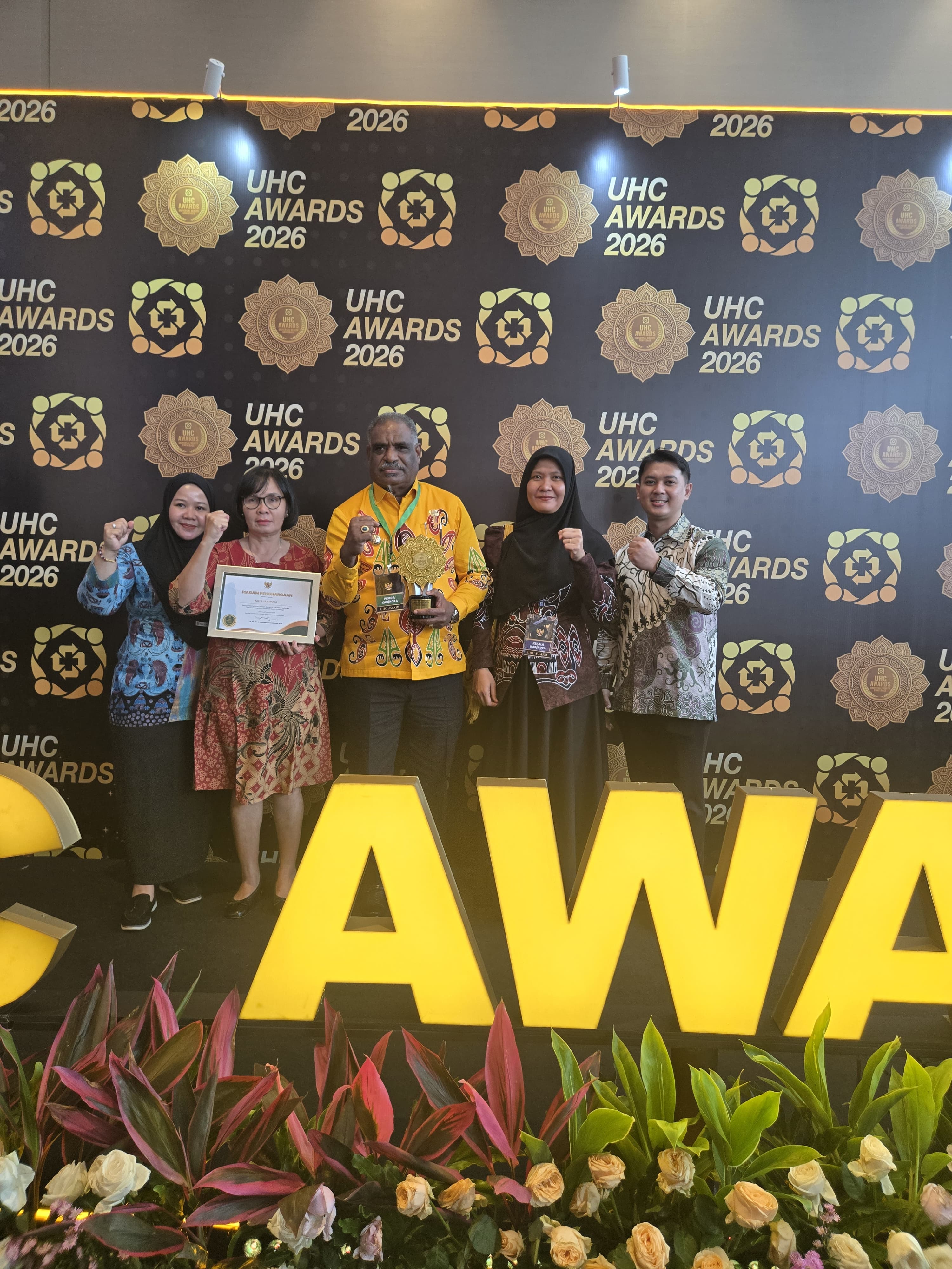 Wali Kota Jayapura, Abisai Rollo didampingi Plt. Kepala Dinas Kesehatan Kota Jayapura, Juliana Napitupulu saat foto bersama usai terima Penghargaan Universal Health Coverage (UHC).