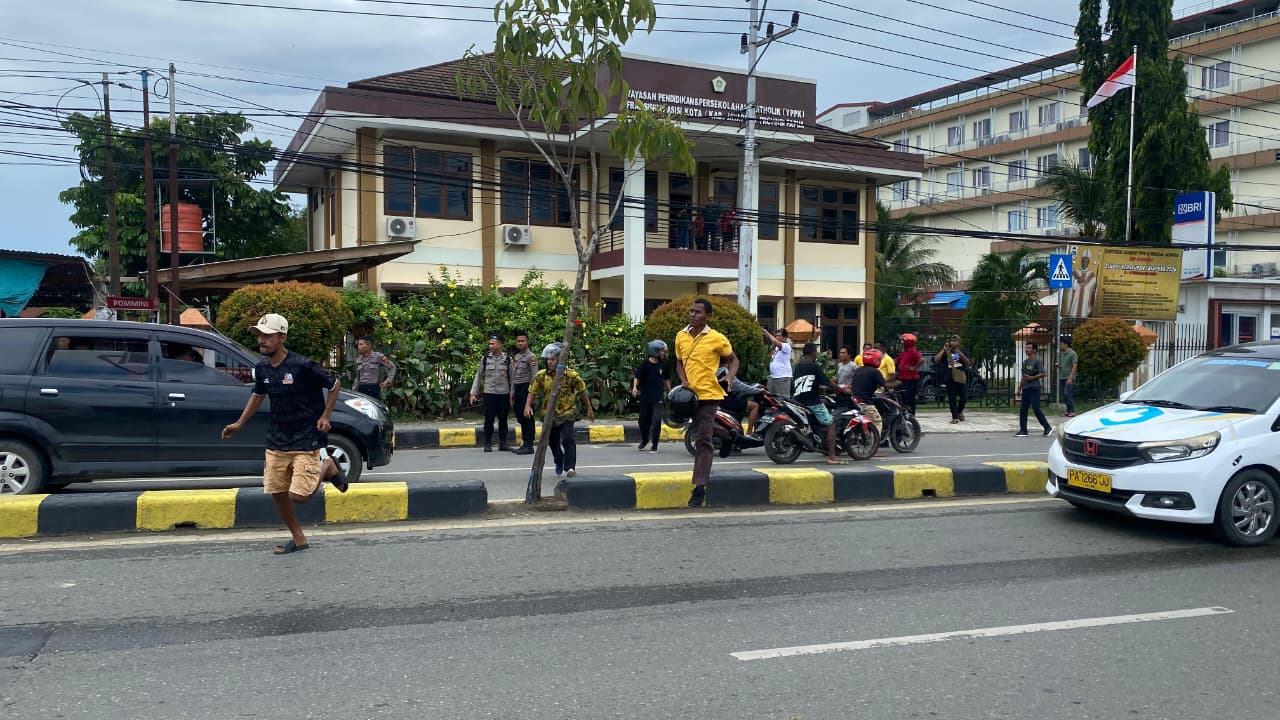 siswa Sekolah Menengah Kejuruan Negeri 3 Jayapura dan Sekolah Menengah Atas YPPK Taruna Dharma Kotaraja saat aksi kejar-kejaran di jalan raya Abepura Kotaraja, Jumat (30/1/2026).